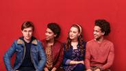 Film still: Simon is sitting on a bench with three friends.